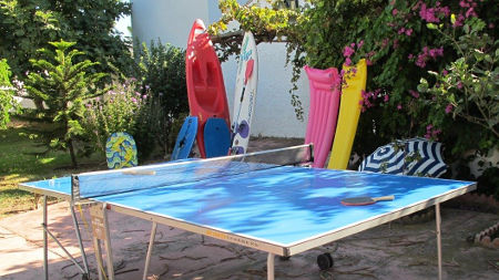 Free time activities in the hostel. In the photo: table tennis, surfboard, air mattress and sunshade